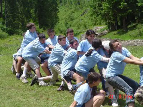 Team in light-blue T-shirts pulling in a tug-of-war contest