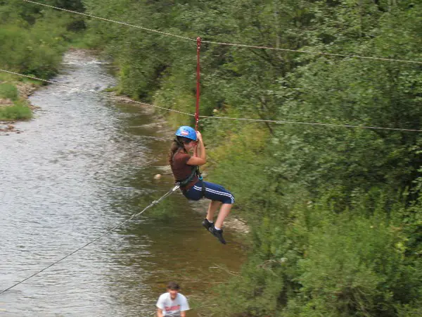 Camper crossing above a mountain river on the zip line
