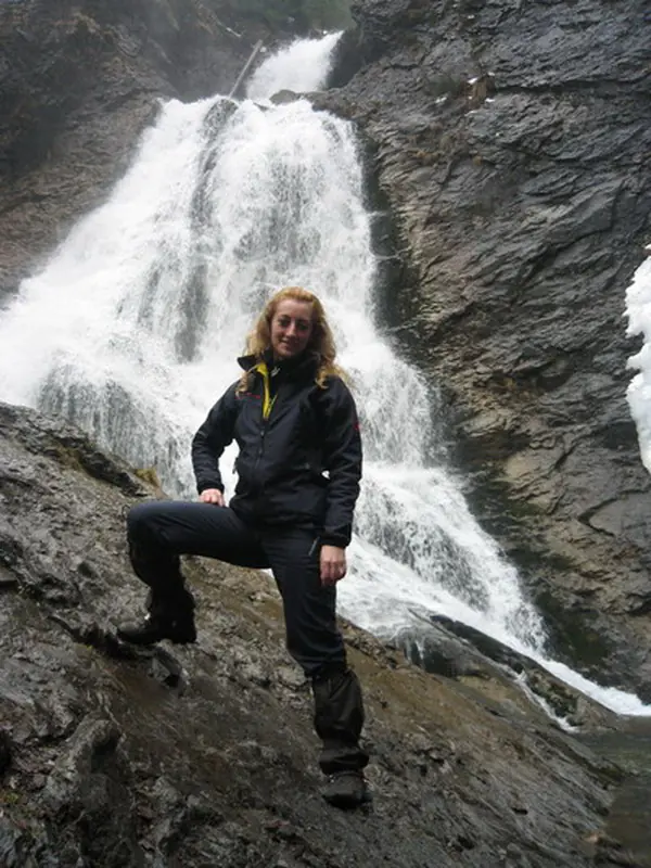Hiker posing on the rocks in front of Vălul Miresei Waterfall