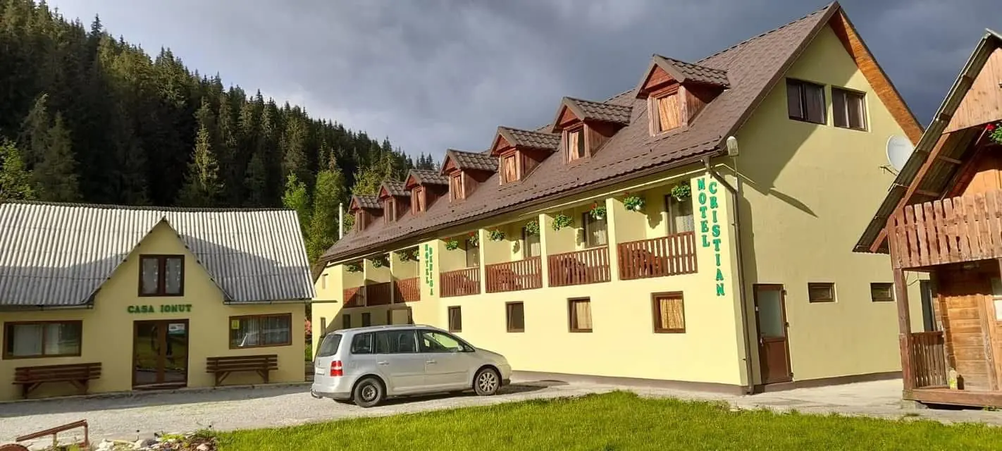 Motel Cristian & Denisa, clădire galbenă cu etaj și balcoane, alături de Casa Ionuț