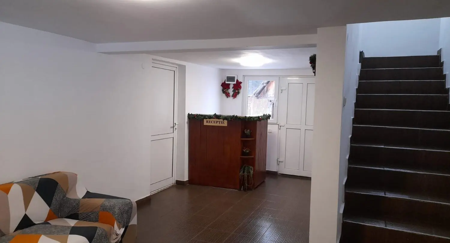 Ground-floor hall with reception desk, sofa and staircase